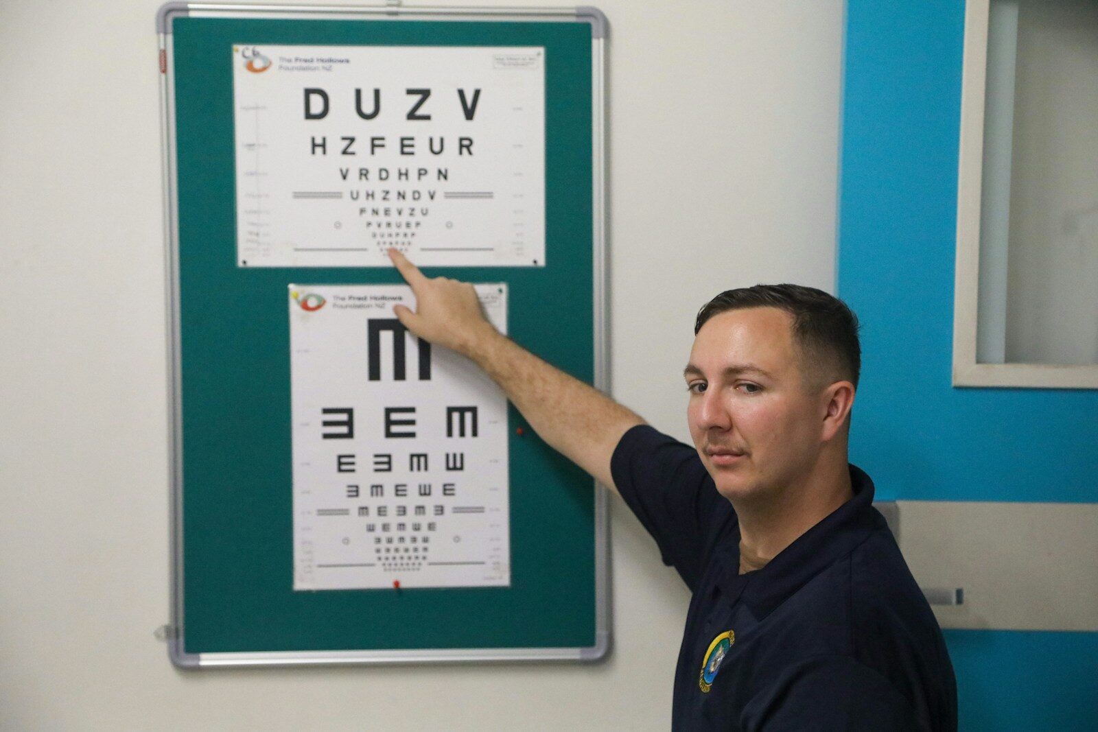 Man points to an eye chart during an exam