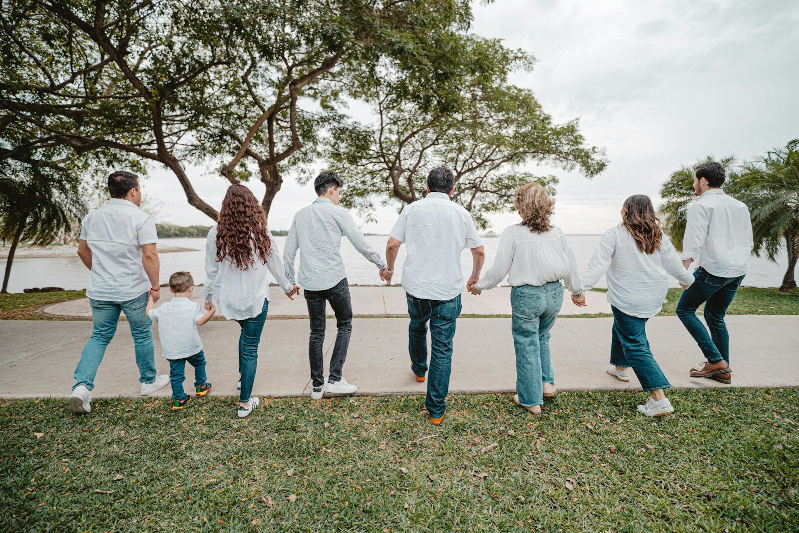 Family holding hands walking by the water